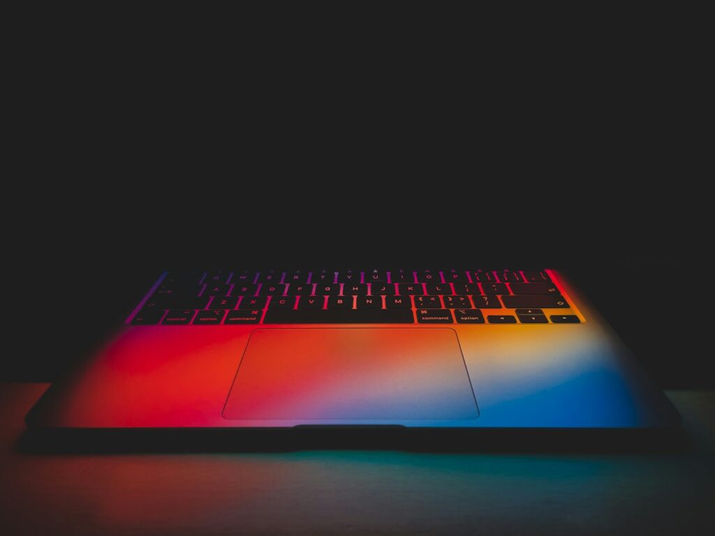 a close up of a laptop with a rainbow keyboard